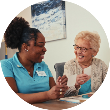 Two women smiling at each other as one of them shows another a card