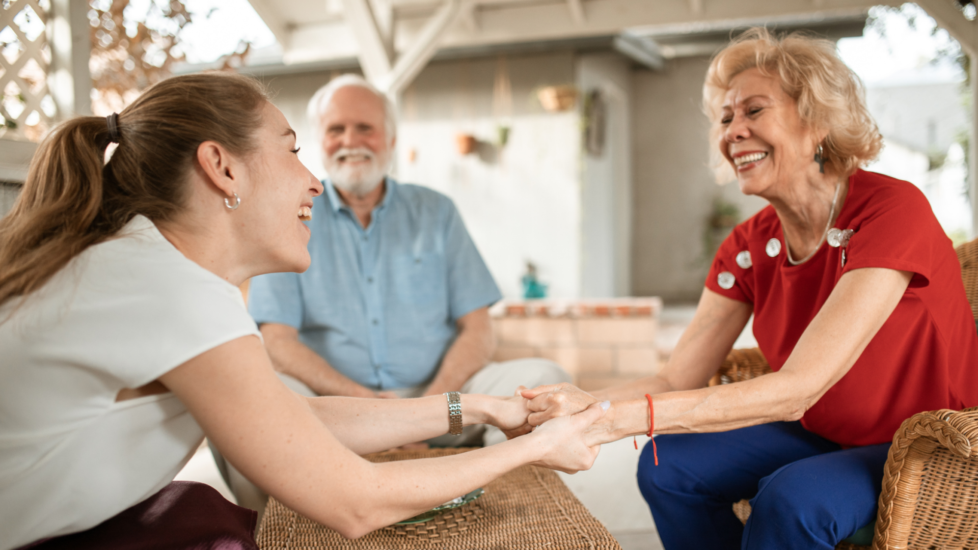 an adult and a senior smiling and holding hands